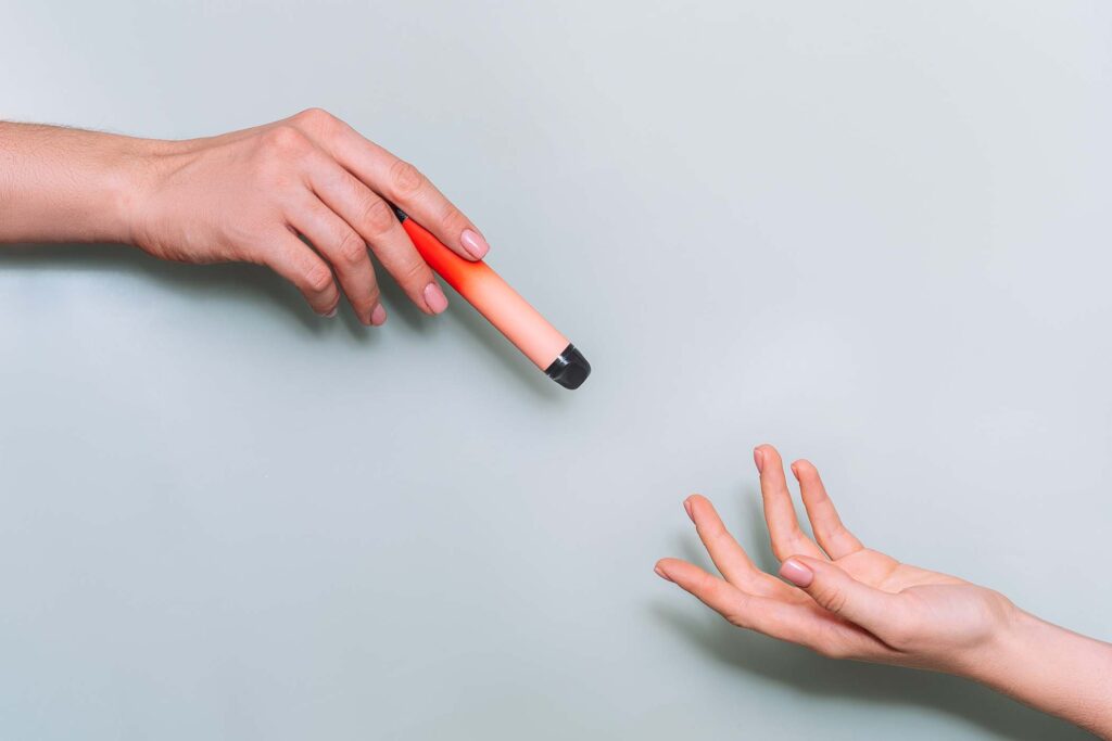 passing-an-electronic-cigarette-from-one-hand-to-a-SECTYNA.jpg